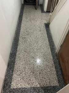 Terrazzovloer met geblokte rand in een hal, na behandeling door Van Heerden